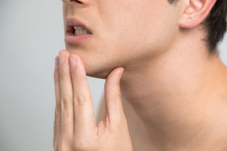 あごを押さえる男性